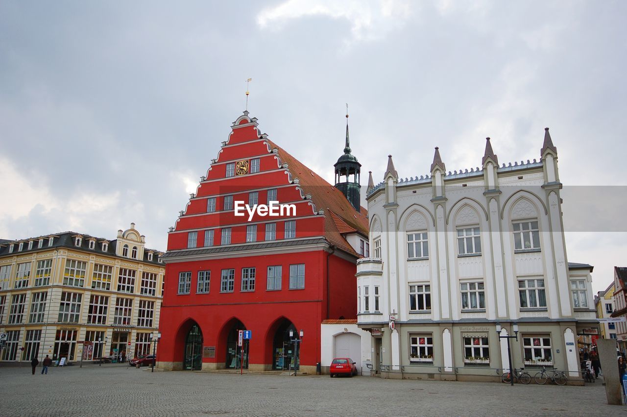 Town hall by buildings against sky in city