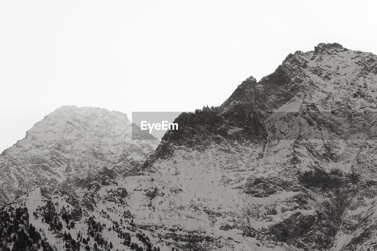mountain, black and white, sky, scenics - nature, beauty in nature, rock, monochrome photography, landscape, nature, environment, mountain range, monochrome, no people, ridge, tranquility, non-urban scene, land, tranquil scene, day, outdoors, clear sky, rock formation, travel, travel destinations, plateau, physical geography, extreme terrain, geology, summit, snow, low angle view, tourism, idyllic, mountain peak, remote