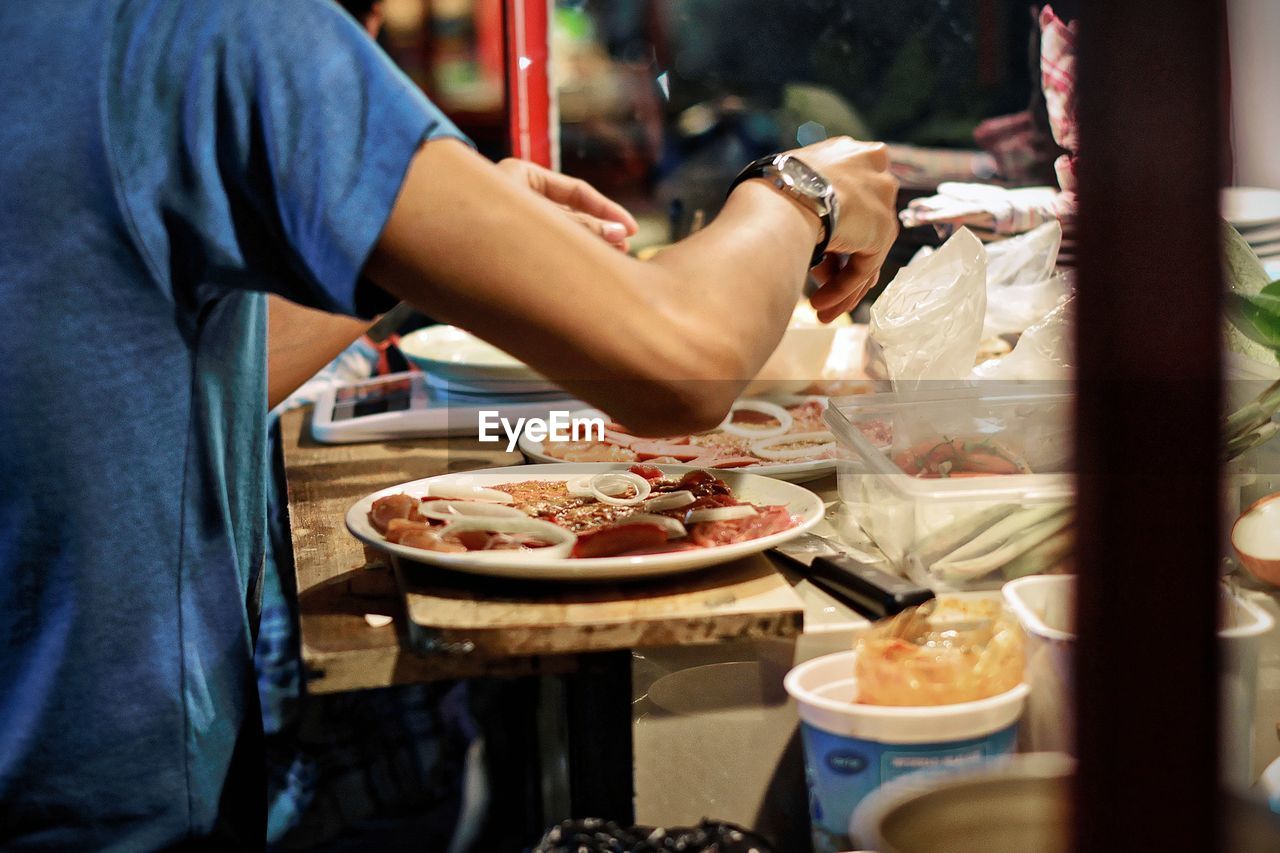 Midsection of vendor preparing food at concession stand