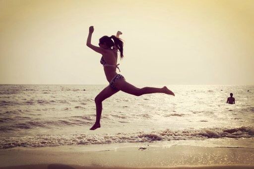 WOMAN JUMPING ON BEACH