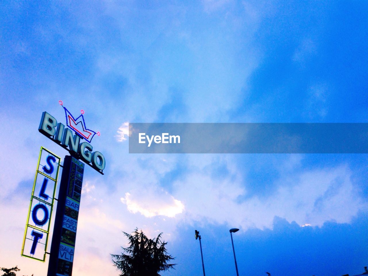 LOW ANGLE VIEW OF SIGN BOARD AGAINST BLUE SKY