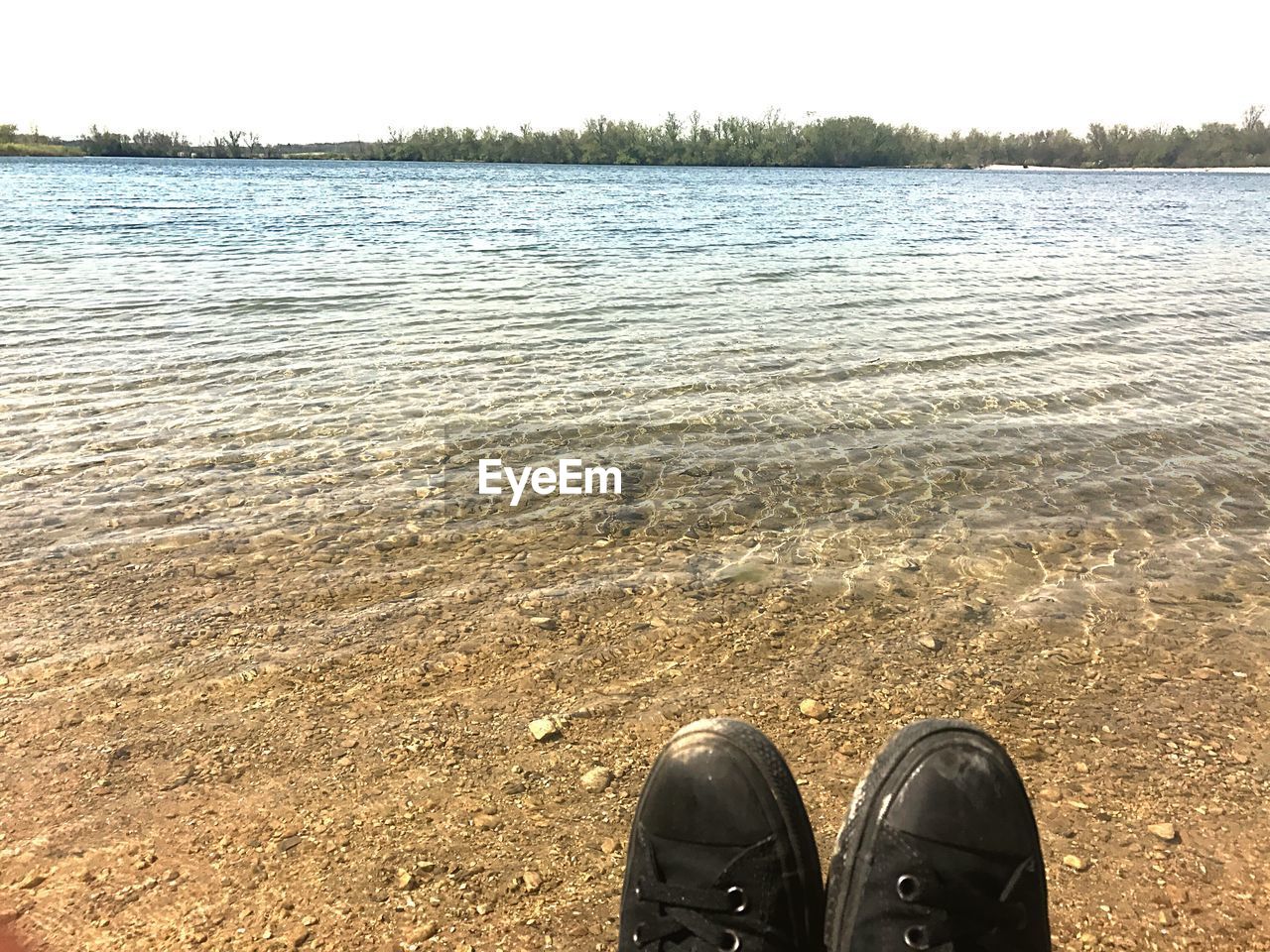 LOW SECTION OF PERSON STANDING ON LAKE