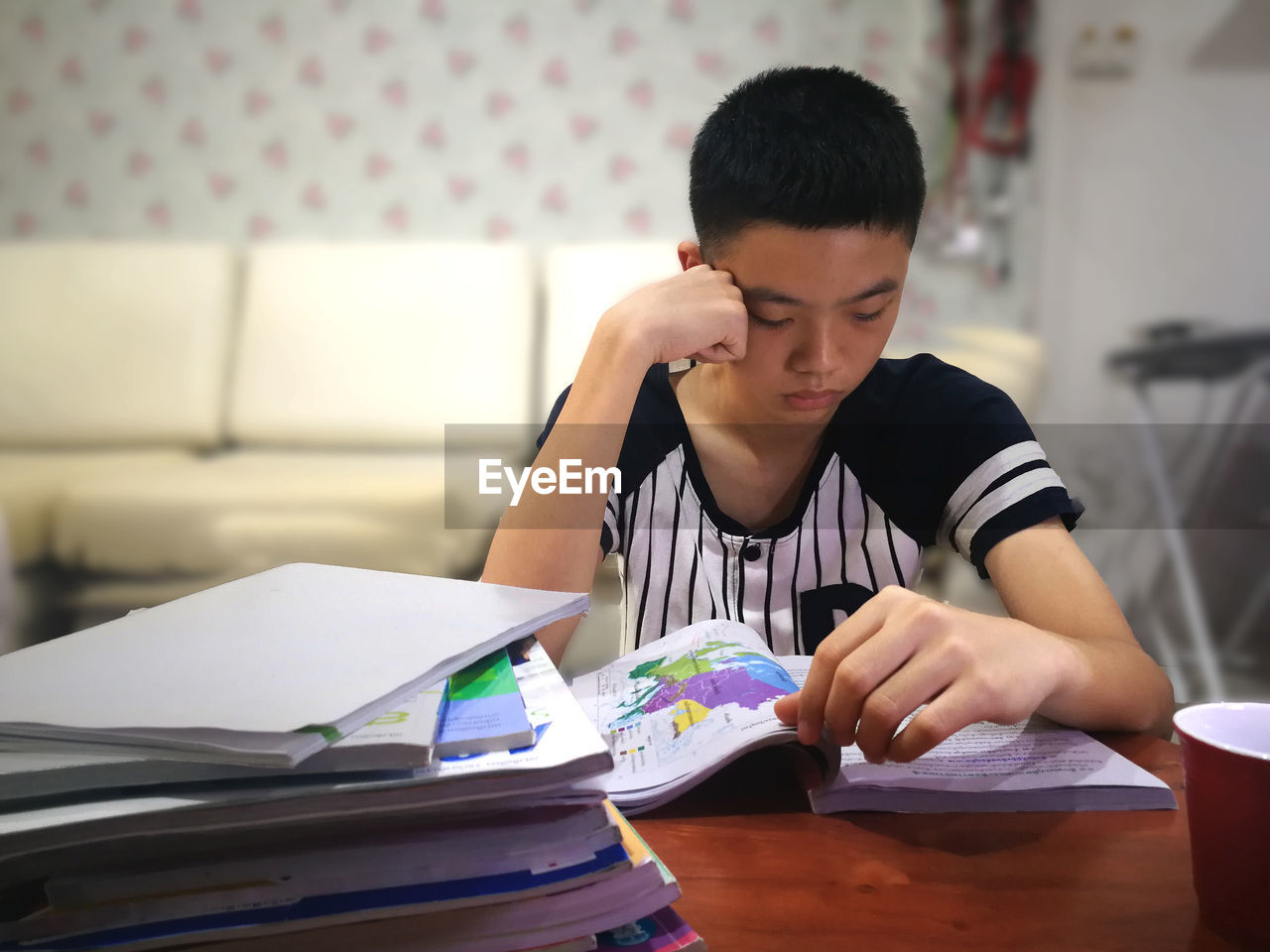 Boy reading book at table