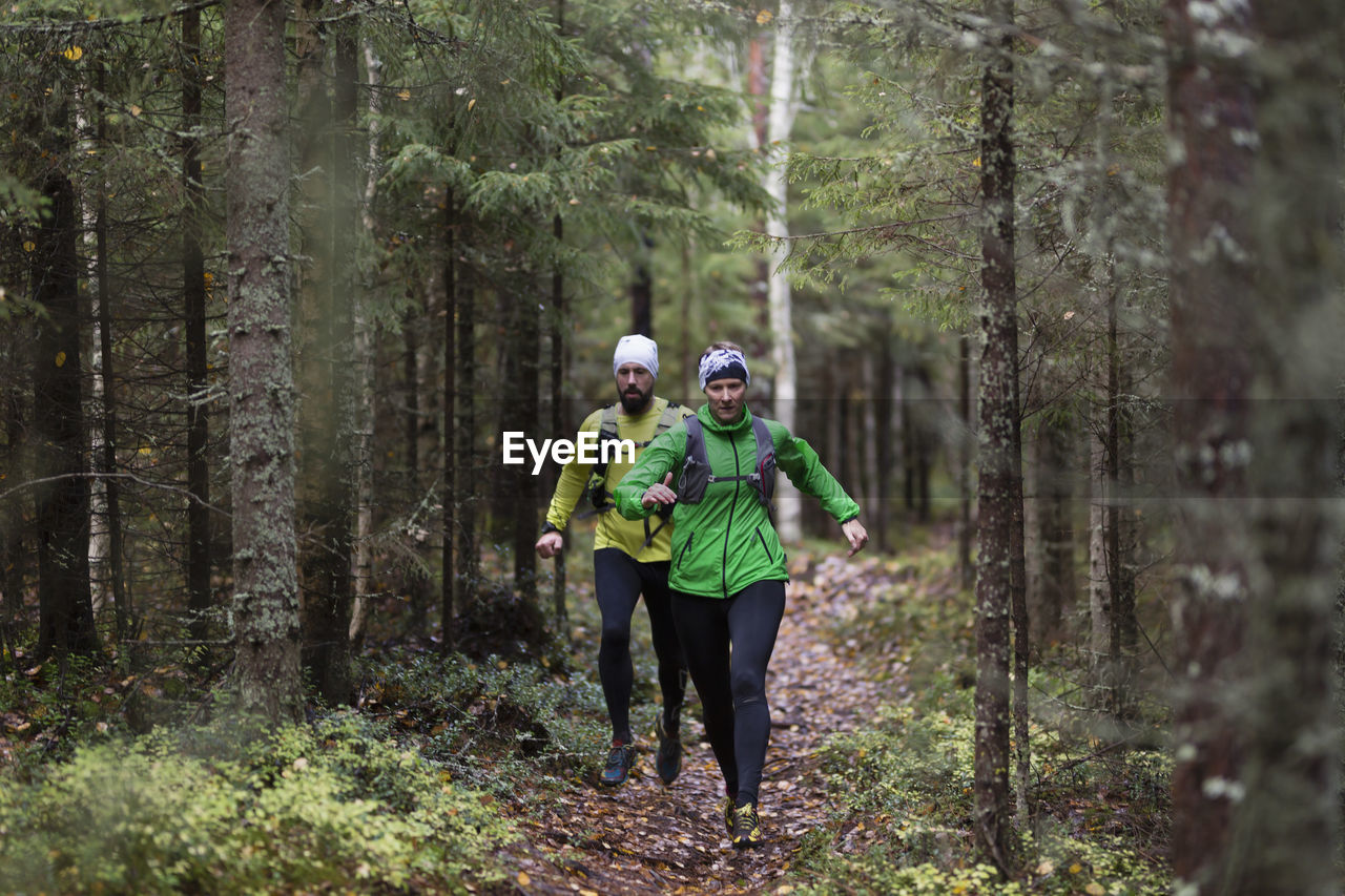 Man and woman running in forest