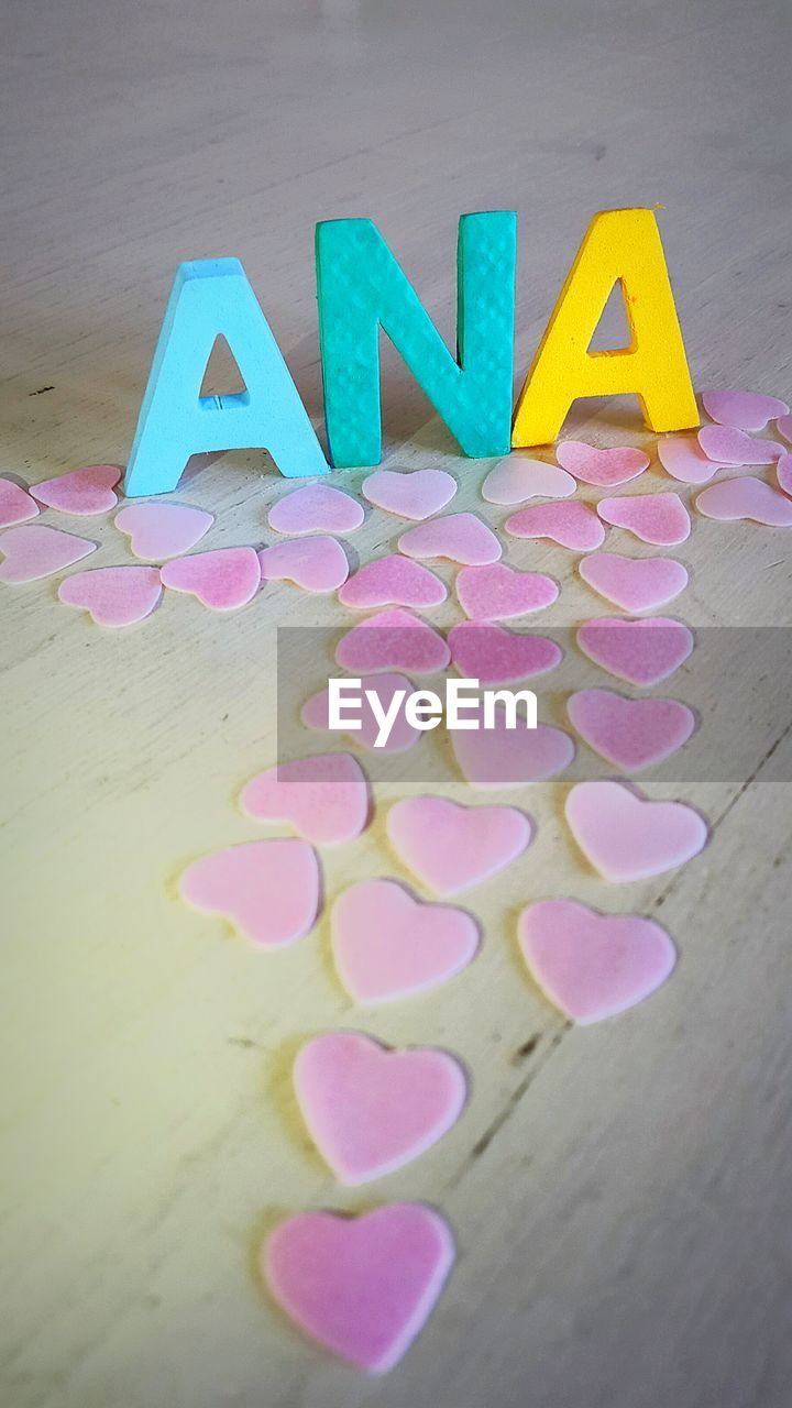 High angle view of text and heart shaped cardboard on table