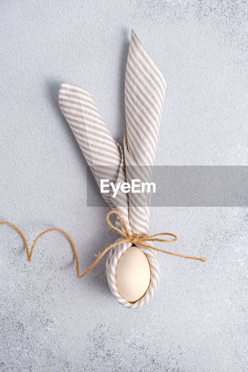 fashion accessory, no people, indoors, still life, jewellery, wing, studio shot, close-up, necklace, high angle view, white, ribbon, creativity, knot, gray, craft, textile, directly above, simplicity