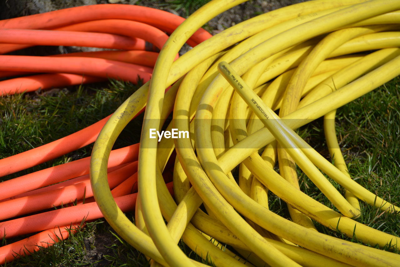 High angle view of garden hoses on grassy field