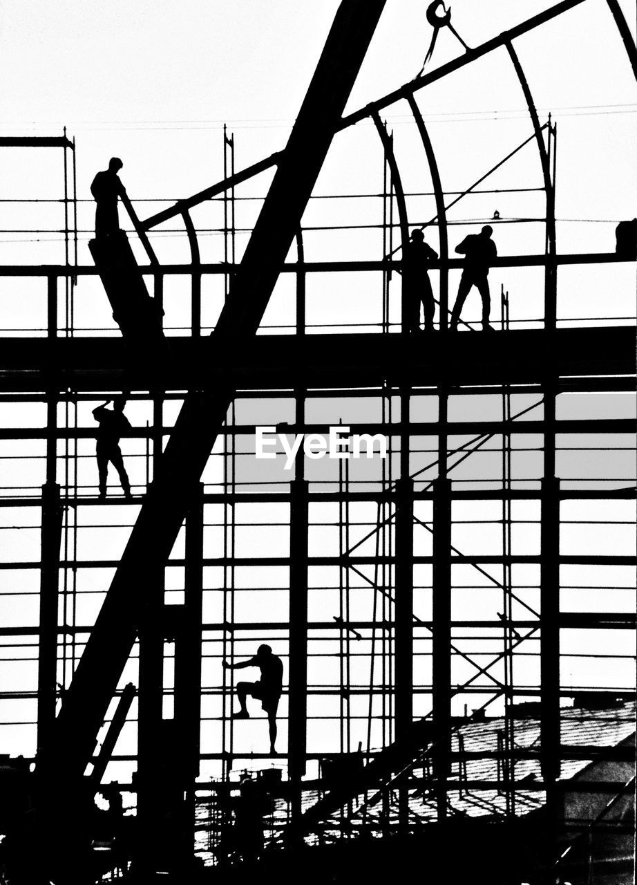 Silhouettes of men on scaffolding