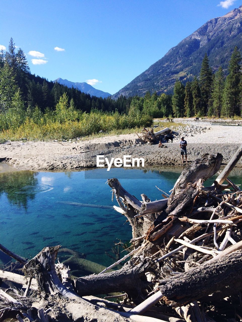 Mid distance view of man by lake against mountains