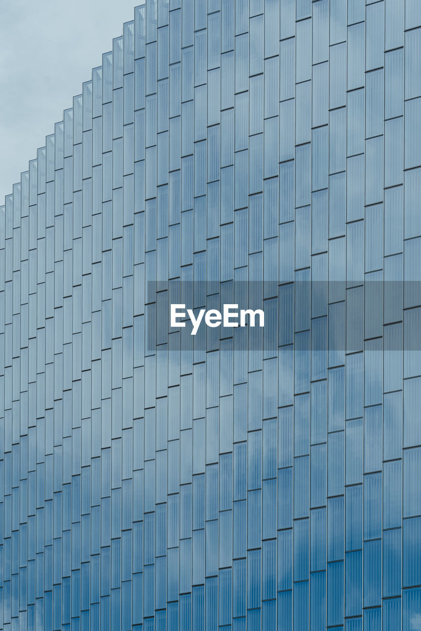 Low angle view of modern building against blue sky