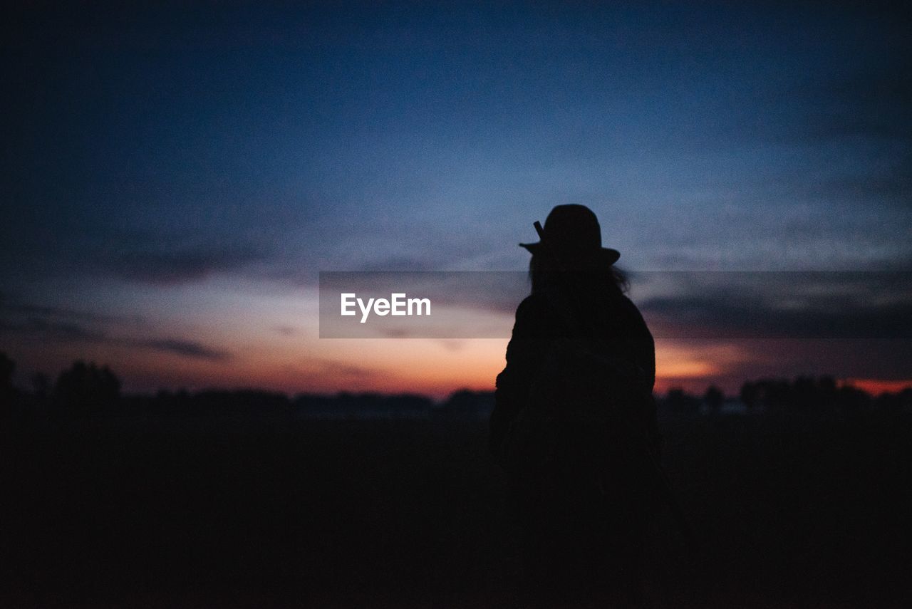 Silhouette woman standing against sky during sunset