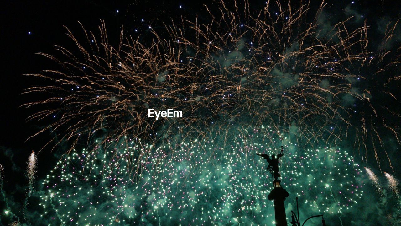 Low angle view of fireworks in sky at night