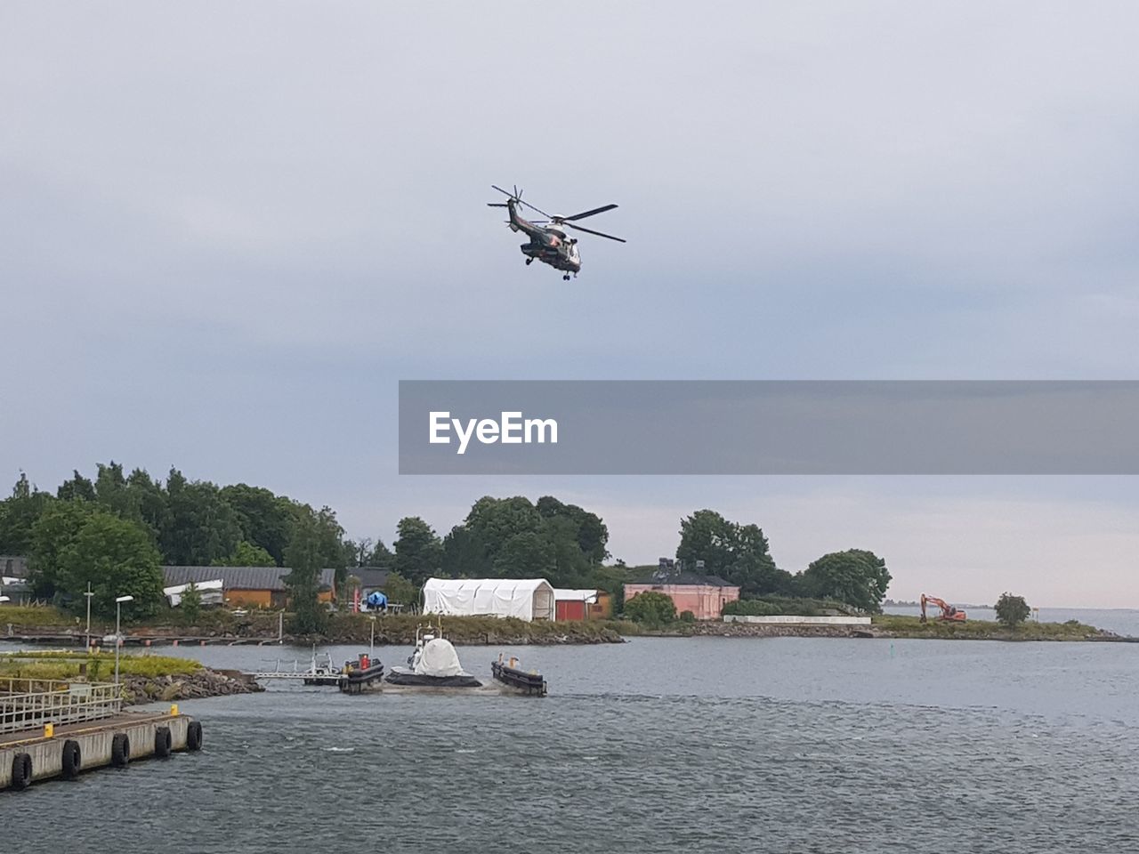 VIEW OF HELICOPTER OVER RIVER AGAINST SKY