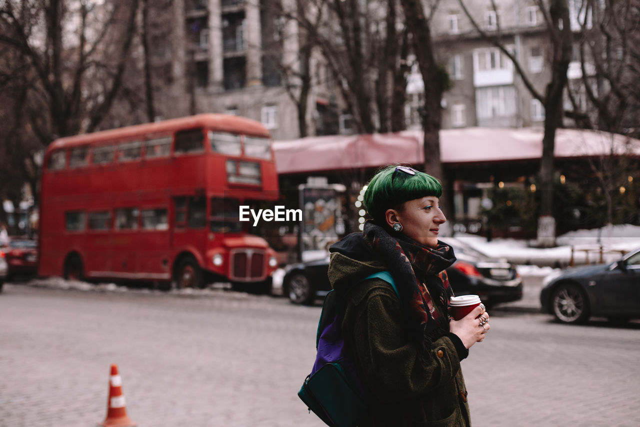 Portrait of non-binary female hipster standing on street in city