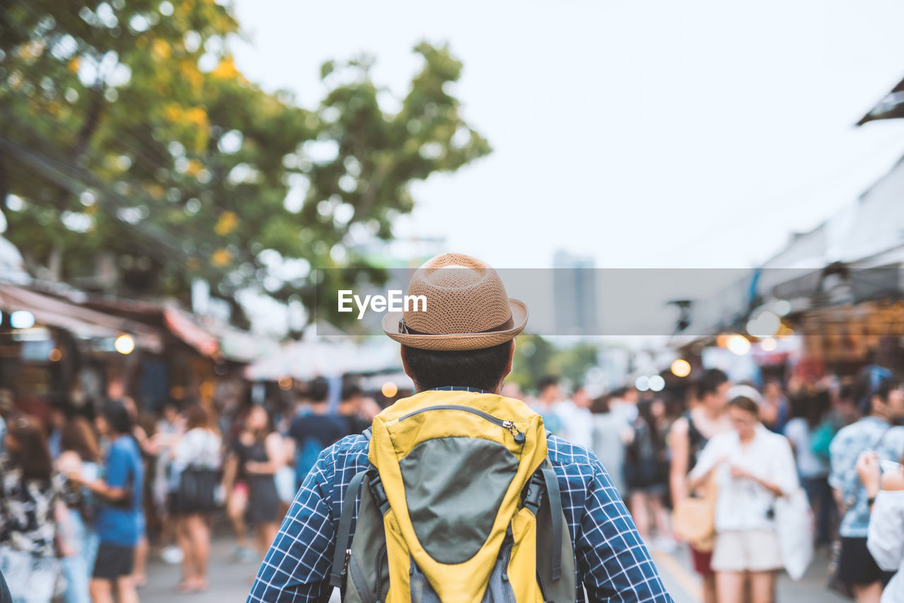 Man wearing hat while standing at market in city