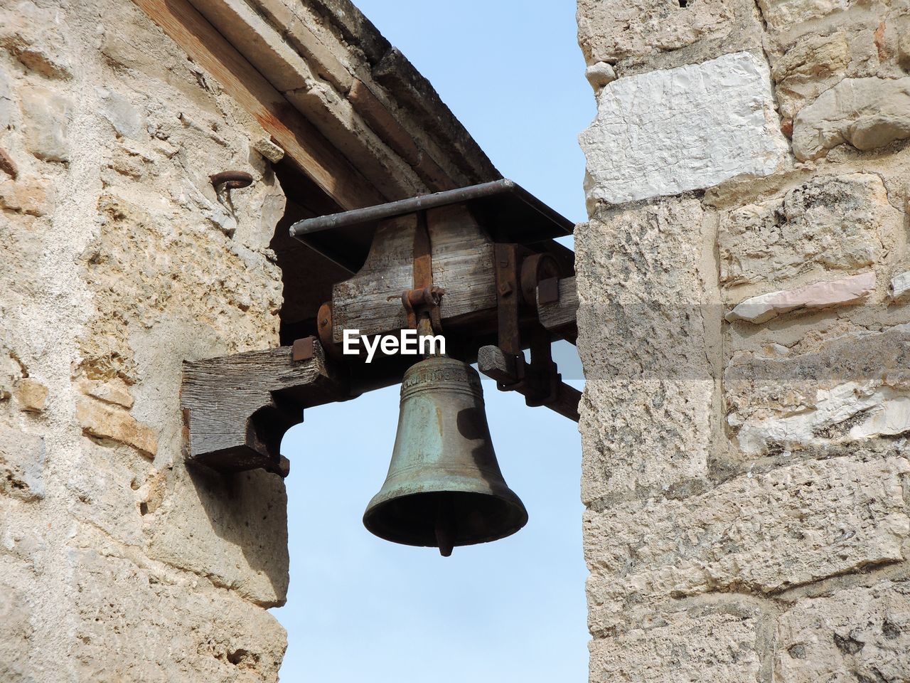 bell, church bell, architecture, temple, built structure, history, the past, wall, ancient history, low angle view, building exterior, nature, day, rock, no people, ancient, musical instrument, religion, old, outdoors, stone wall, travel destinations, wall - building feature, bell tower, sky, stone material, belief, building, old ruin, place of worship, hanging, sunlight, spirituality, clear sky, travel