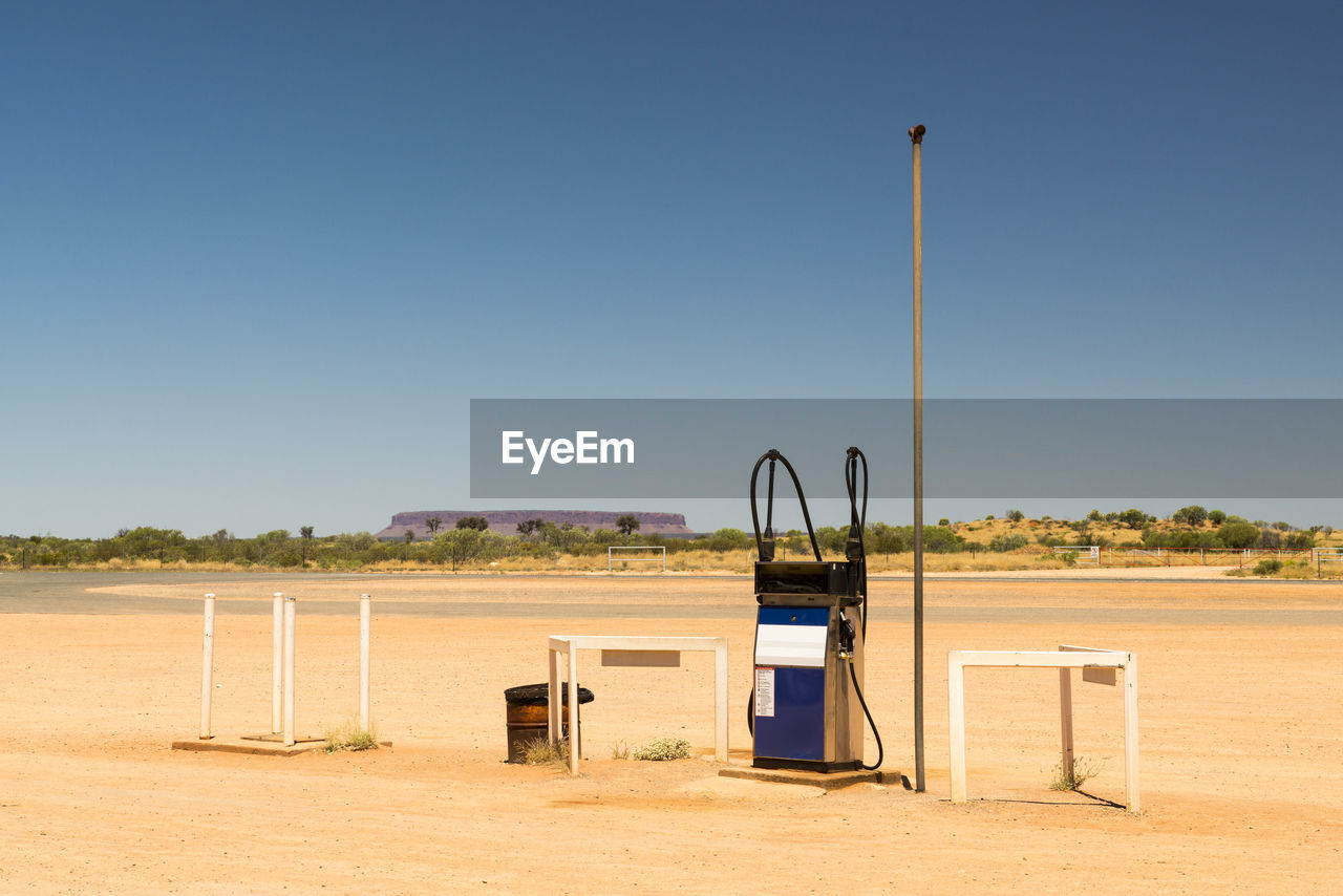 Fuel pump at desert against clear blue sky