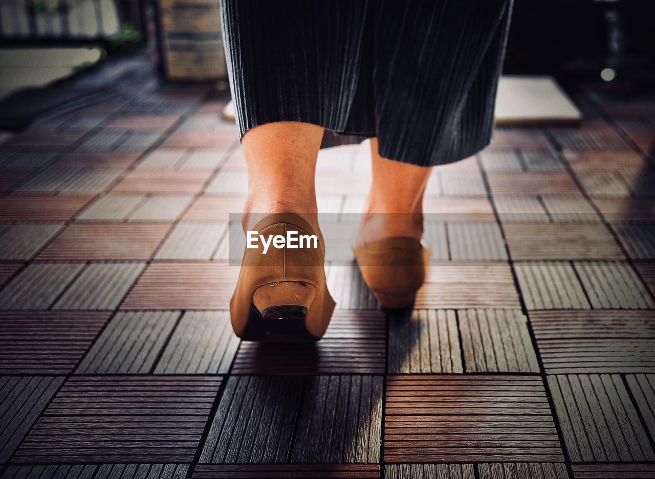 Low section of woman walking on floor