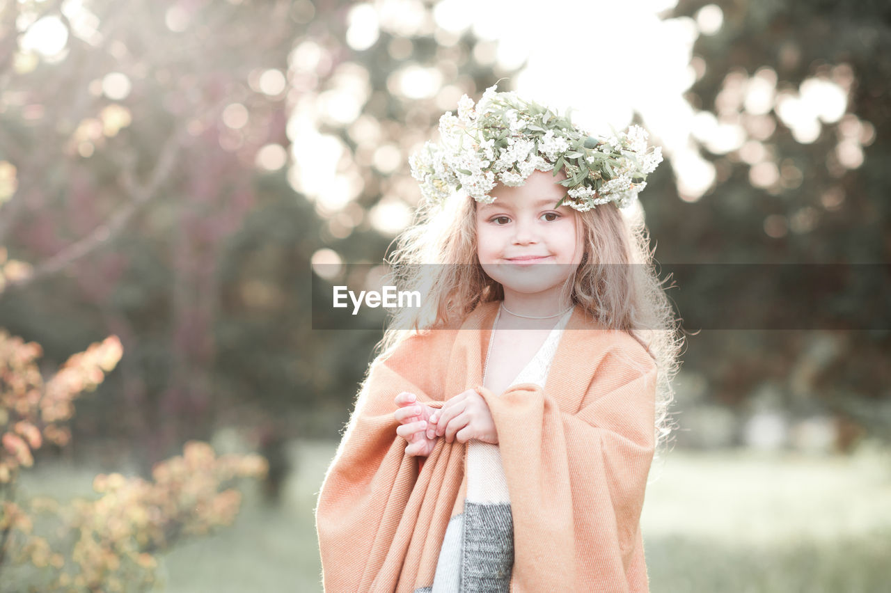 Portrait of girl wearing wreath at park