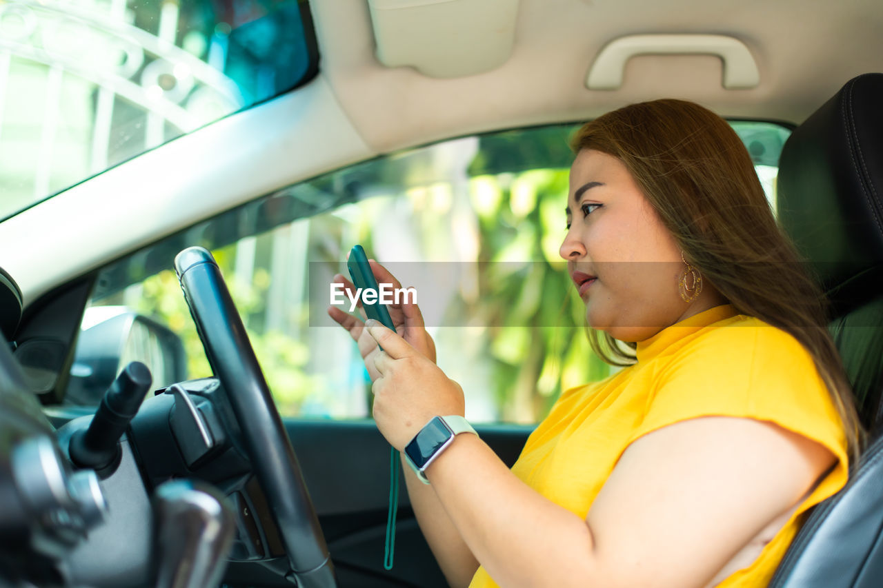 SIDE VIEW OF WOMAN LYING DOWN IN CAR