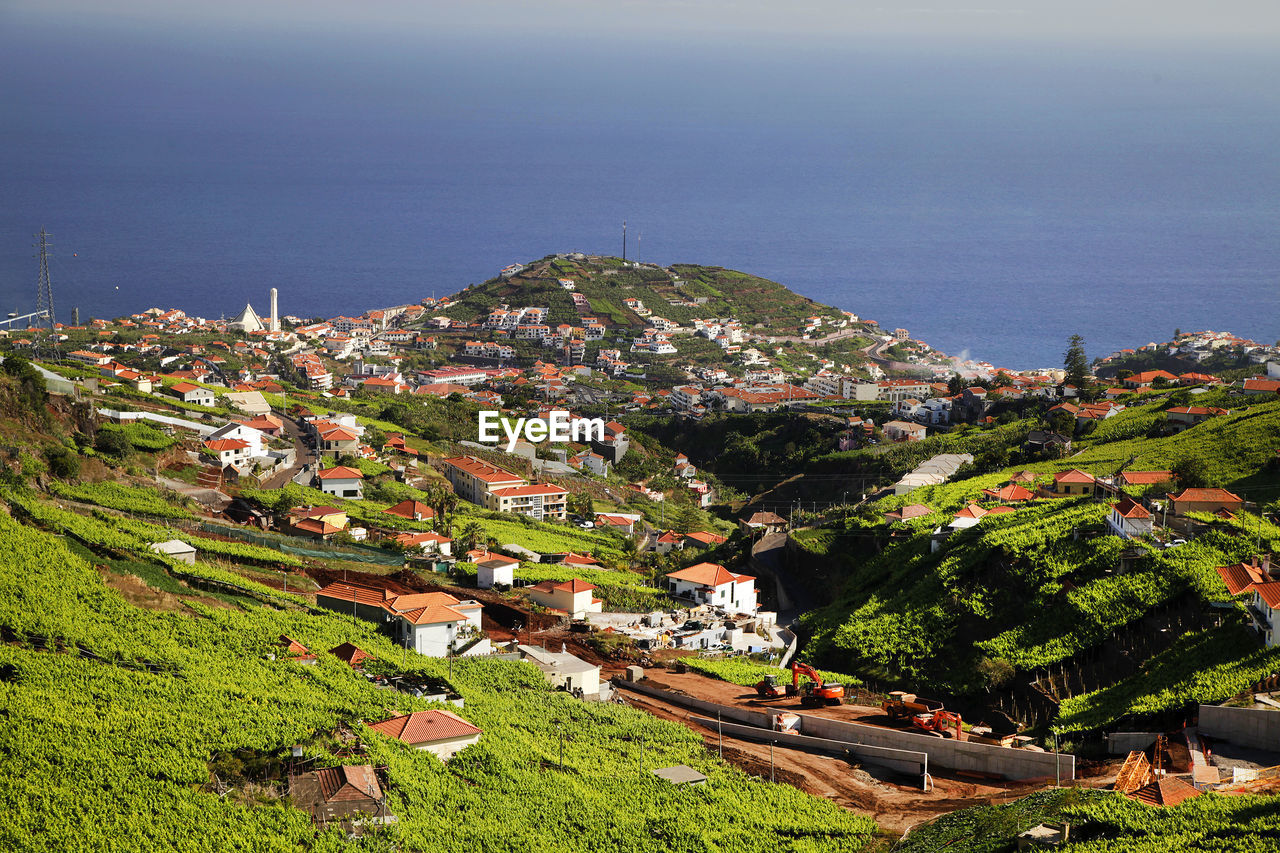 High angle view of residential buildings on mountain by sea