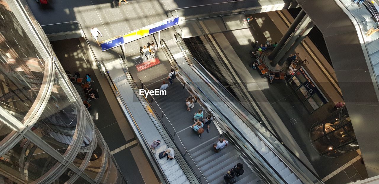 HIGH ANGLE VIEW OF PEOPLE AT ESCALATOR