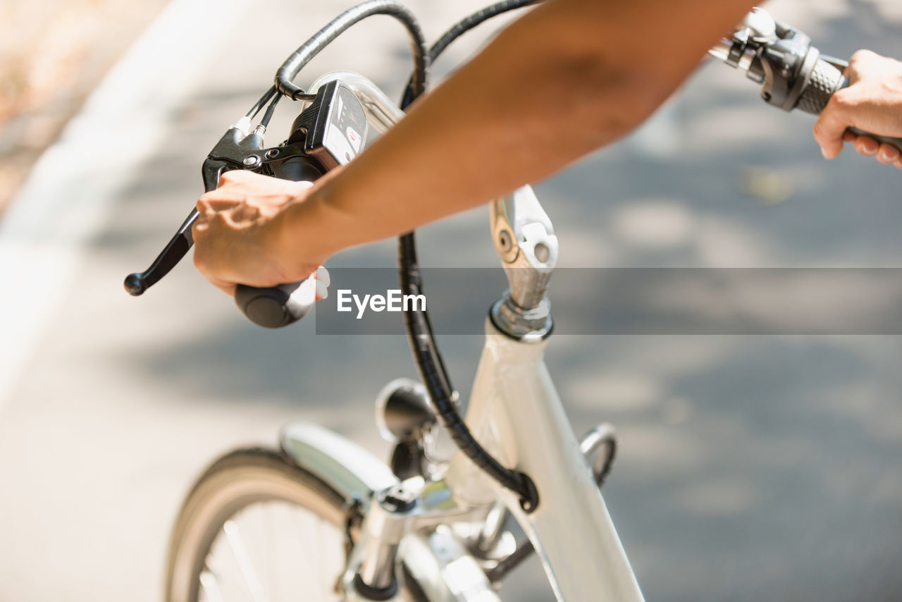 Cropped hands of woman holding bicycle handlebar