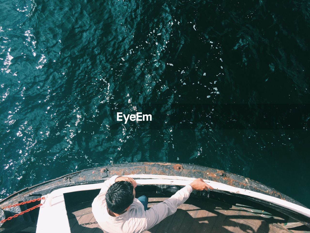 Directly above shot of man standing by railing in boat on sea