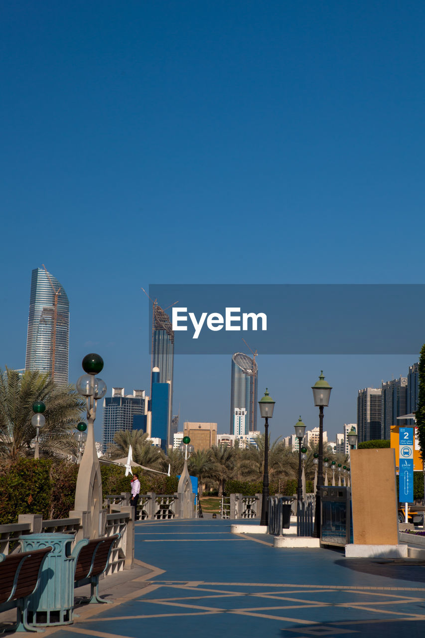 Buildings in city against clear blue sky