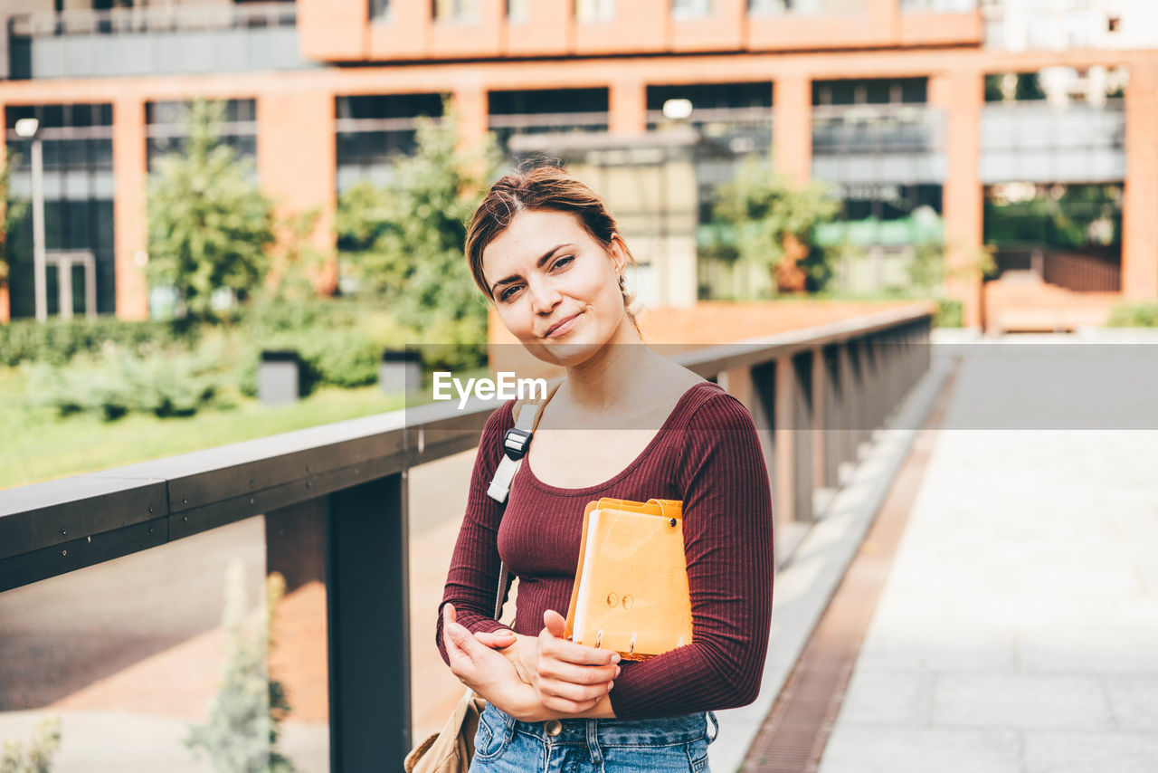 young woman standing against railing