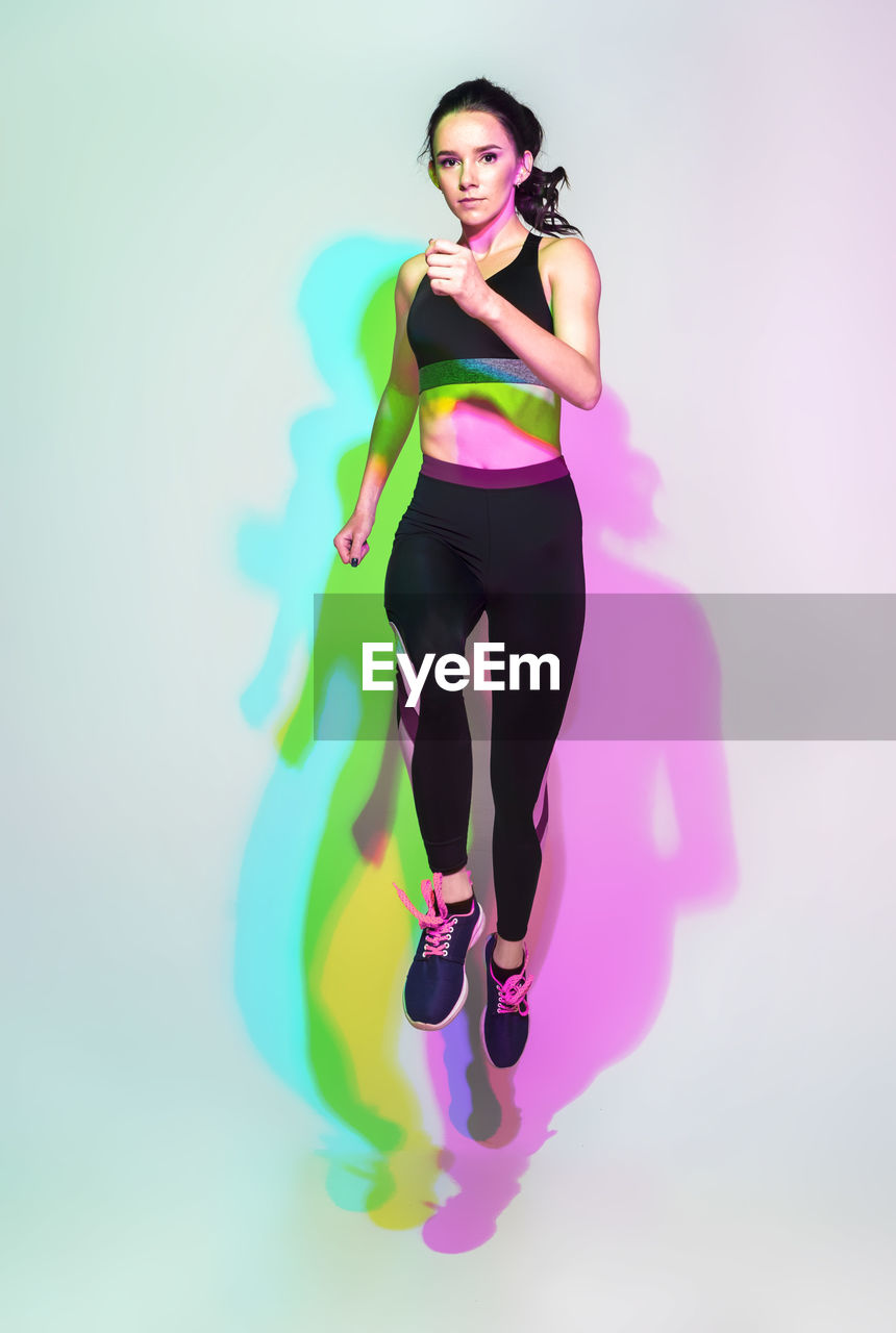 Attractive woman doing stretching exercise or yoga moves with glitch duotone effect