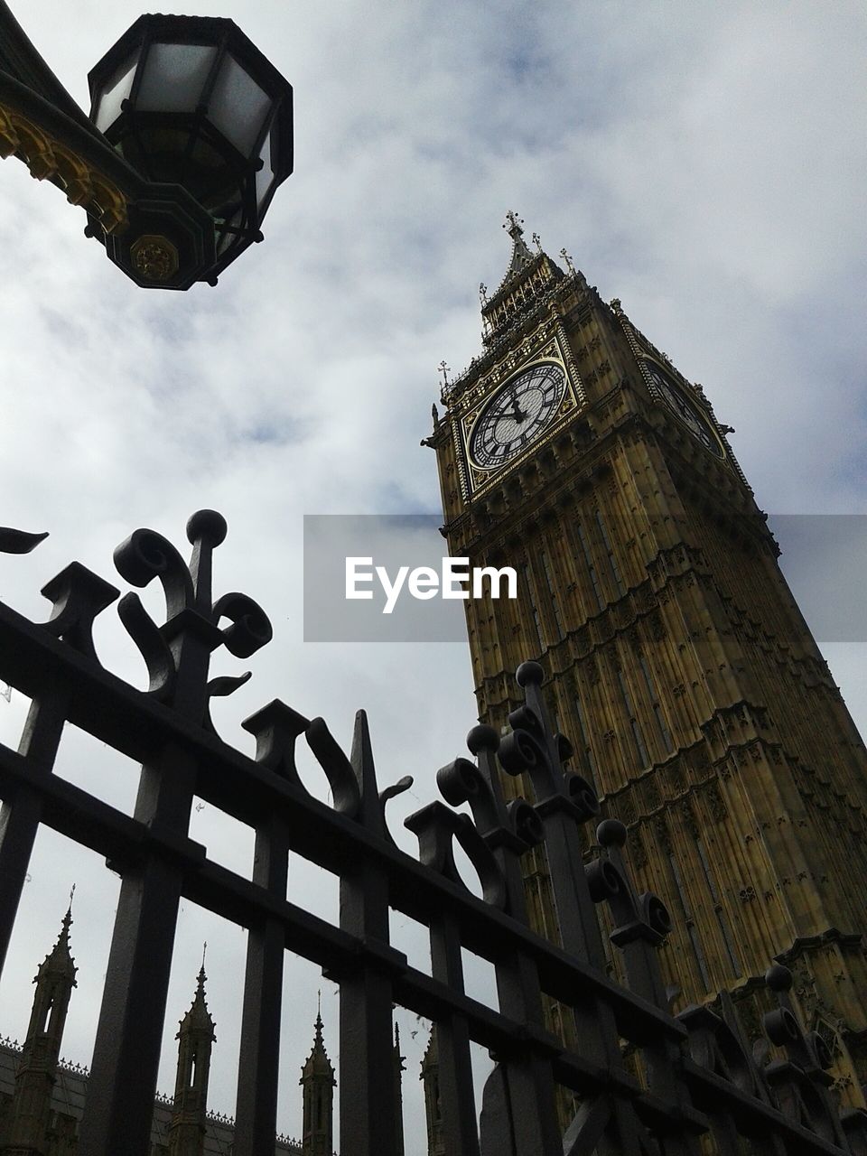 Low angle view of clock tower against cloudy sky