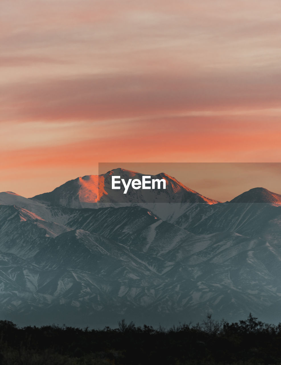 View of the snowy mountain range in the andes with the first lights of