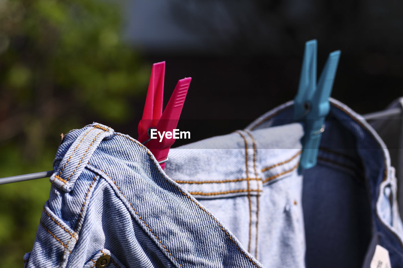 Close-up of clothespins on jeans hanging on clothesline