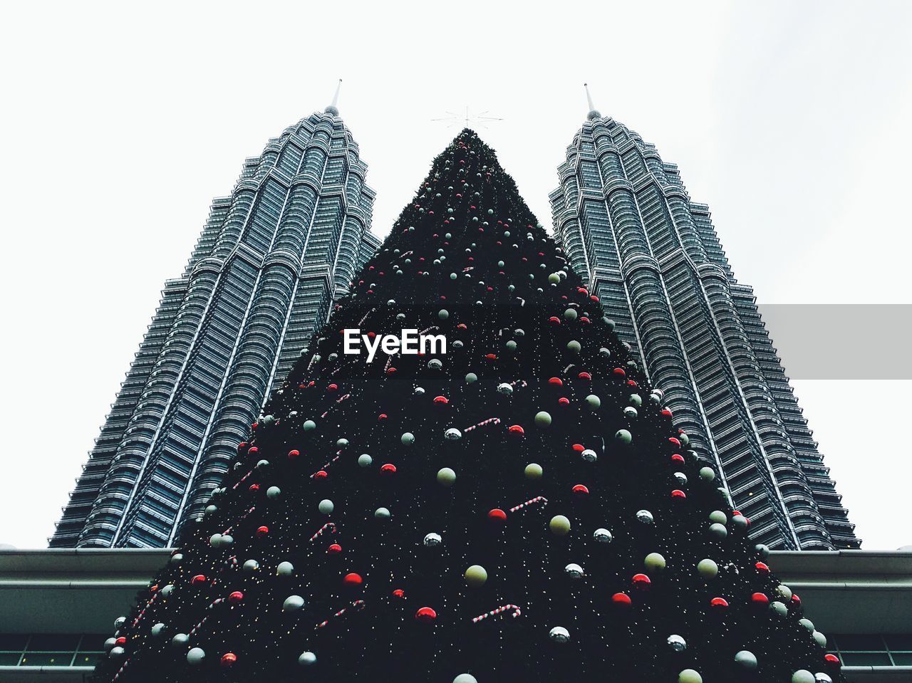 Low angle view of christmas tree at petronas towers against sky