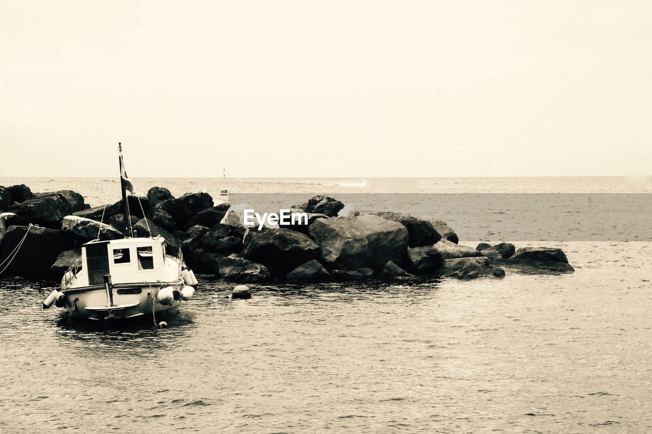 SCENIC VIEW OF SEA AND ROCKS AGAINST CLEAR SKY