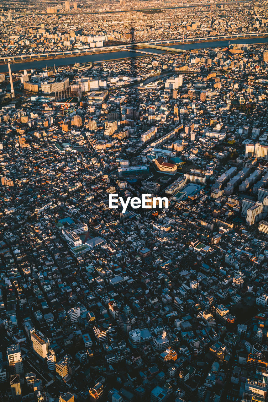 HIGH ANGLE VIEW OF CROWD ON FIELD AGAINST BUILDINGS