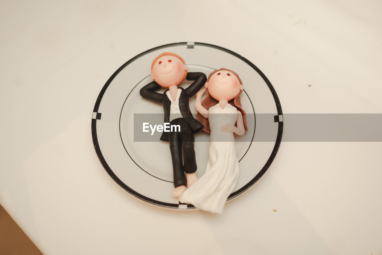 High angle view of dolls in plate on table