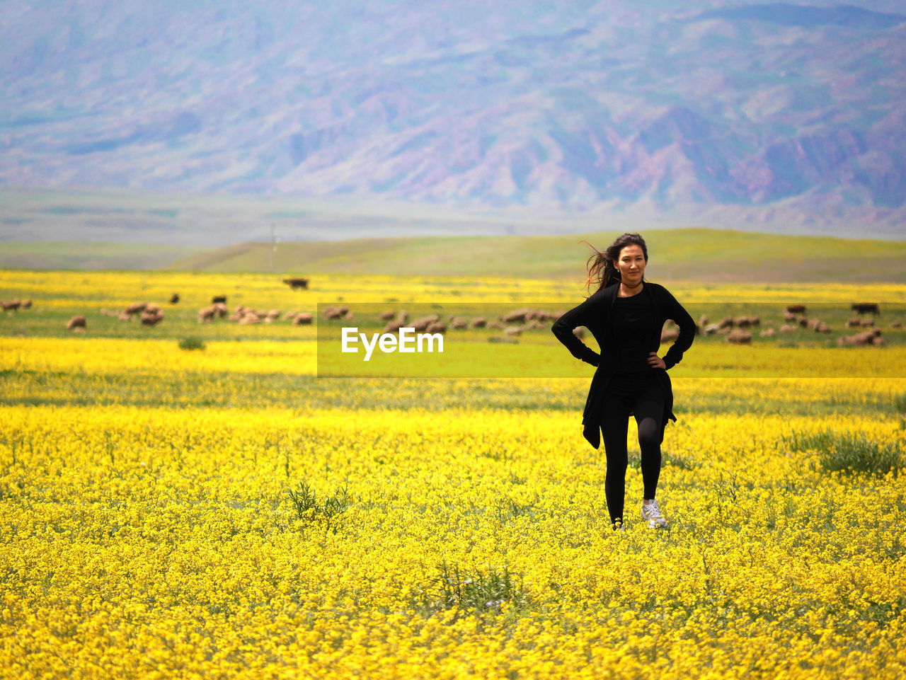 Full length of a smiling young man standing in field