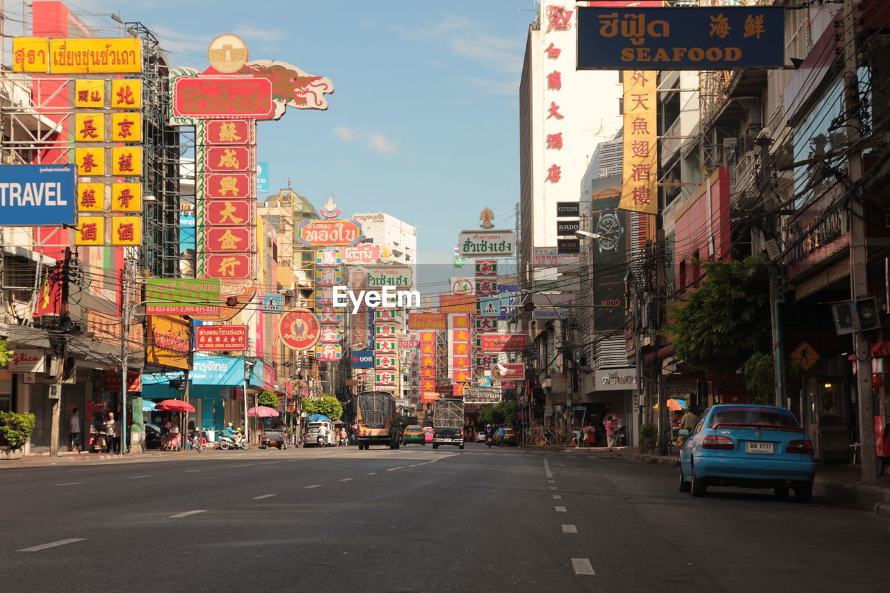 CITY STREET AMIDST BUILDINGS AGAINST SKY