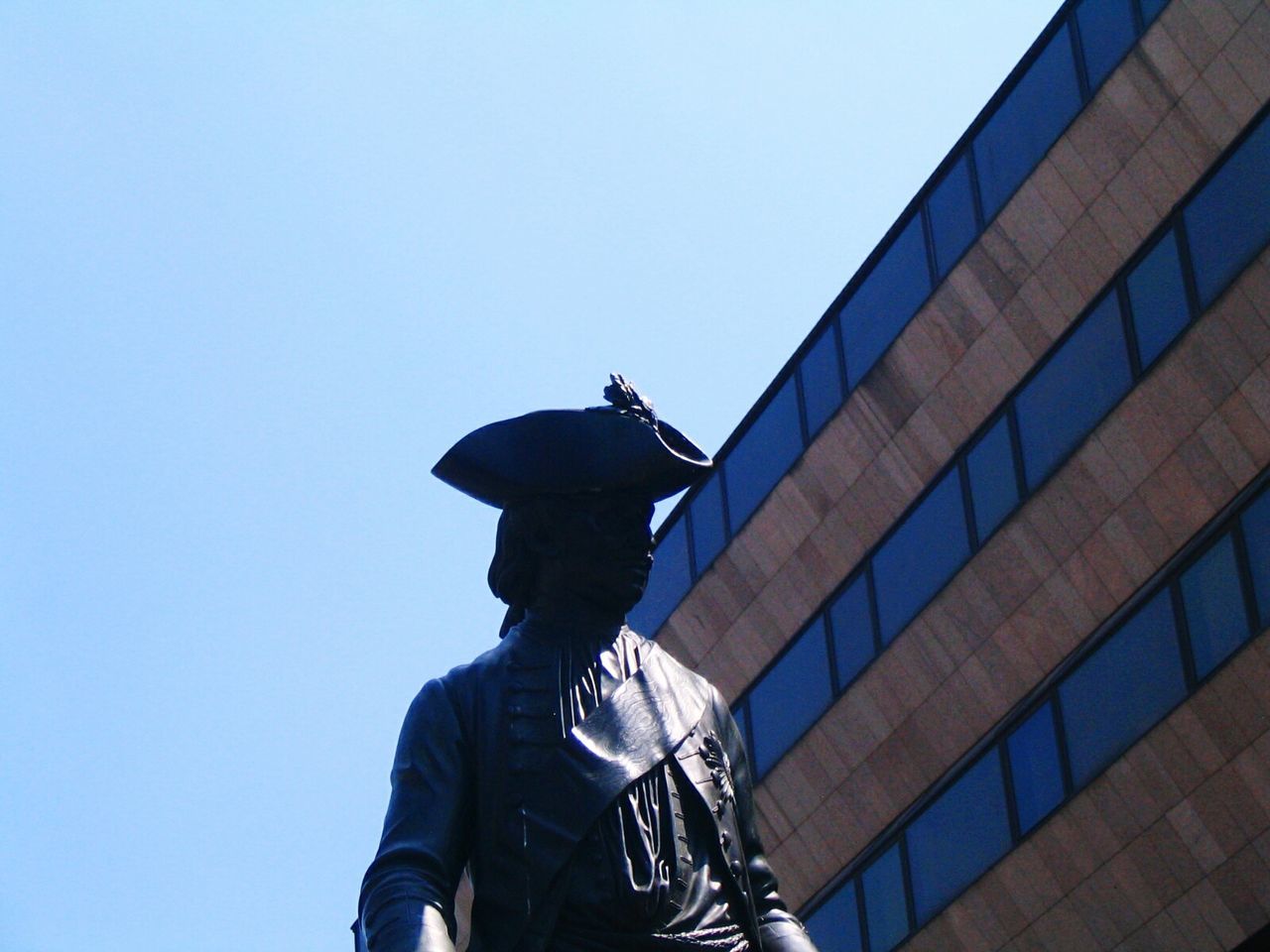 LOW ANGLE VIEW OF MAN AGAINST BUILDING