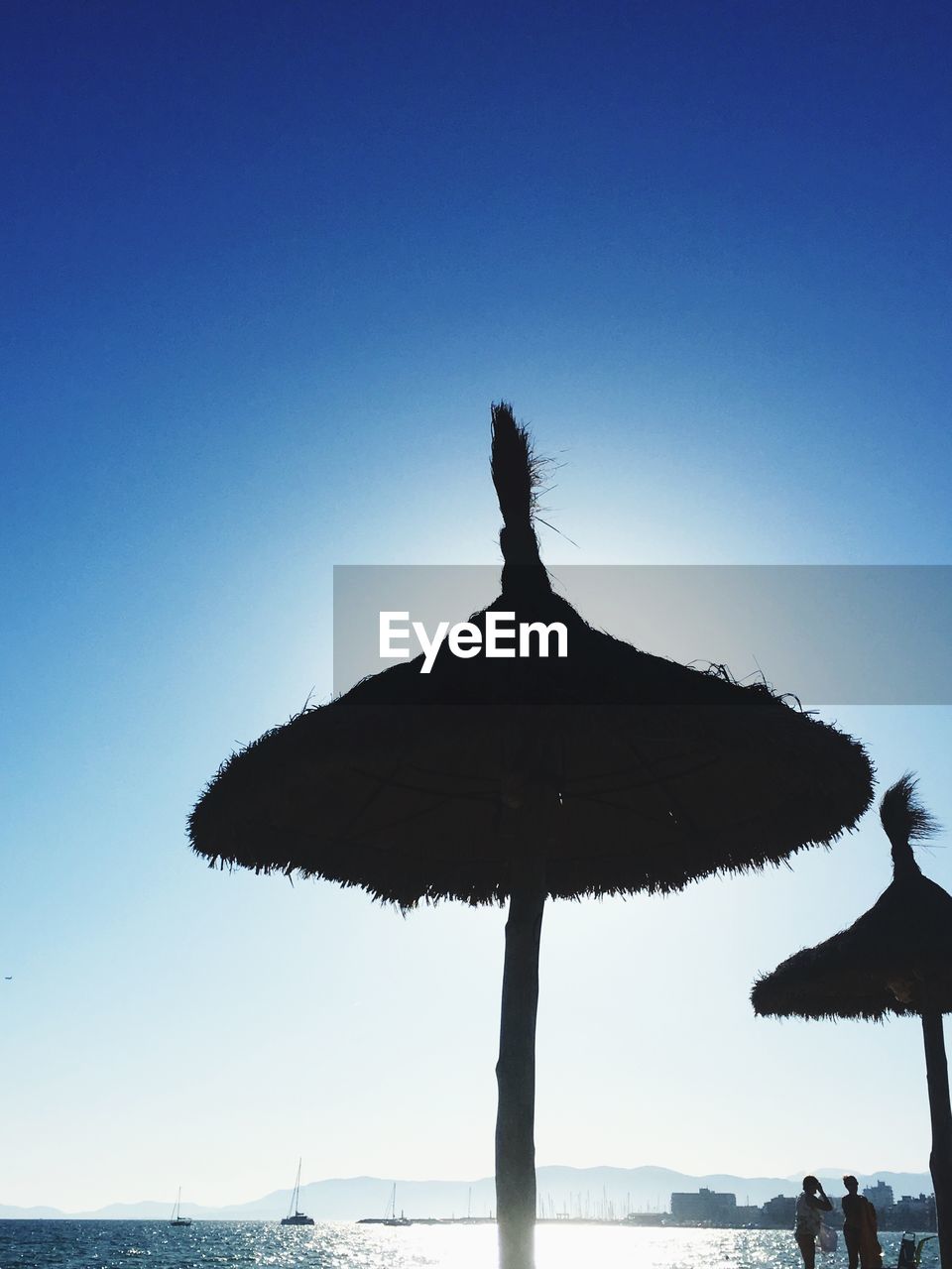 LOW ANGLE VIEW OF SILHOUETTE PALM TREE ON BEACH AGAINST CLEAR SKY