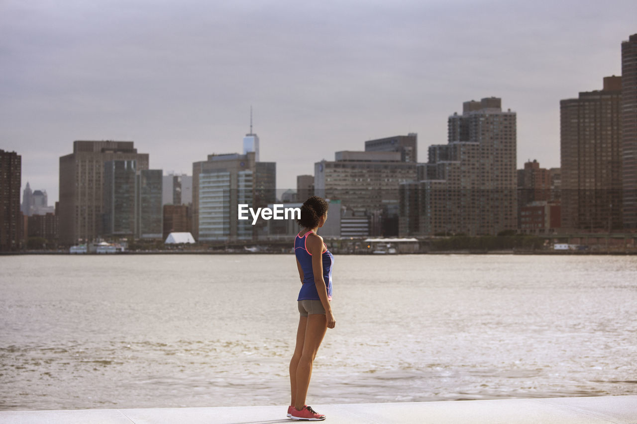 Woman looking at buildings while standing on promenade