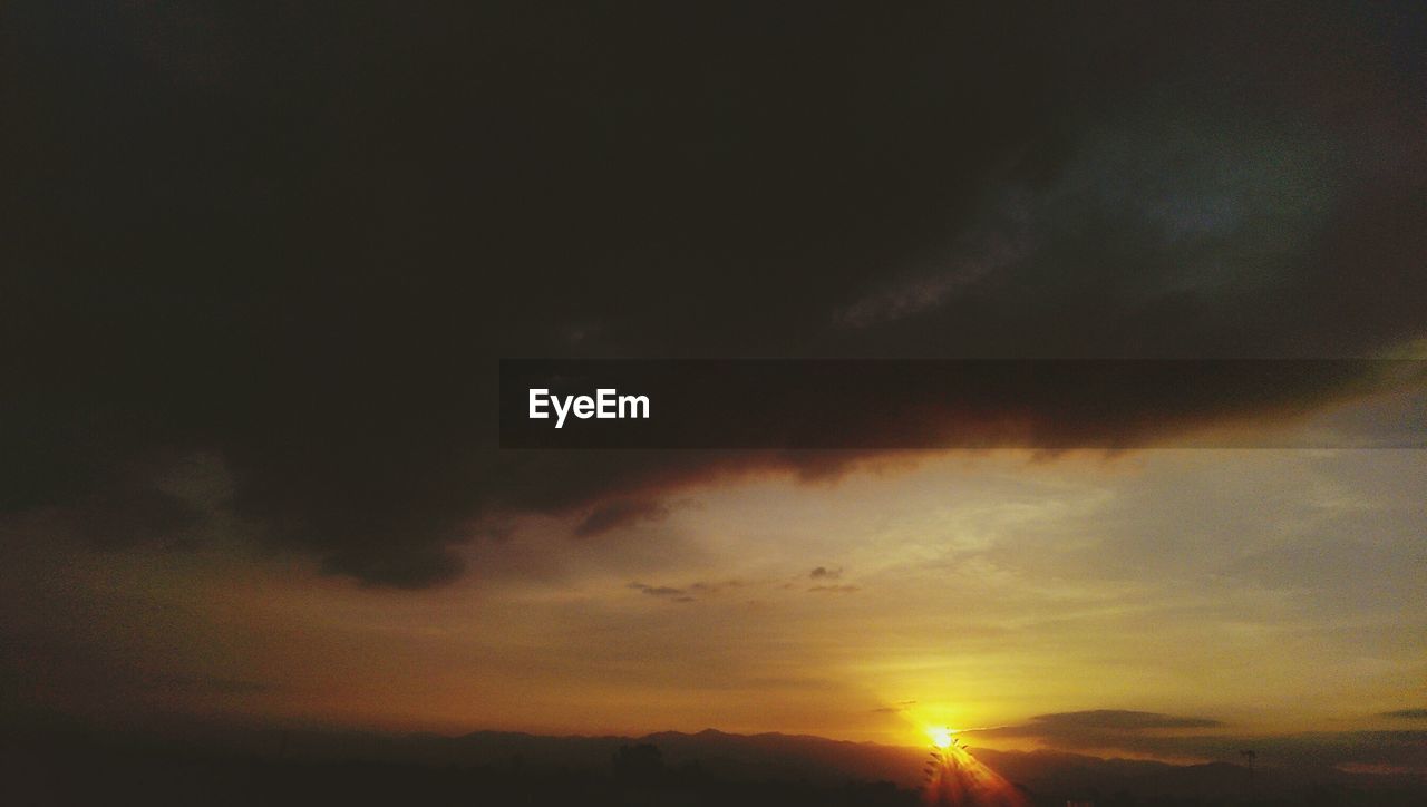 SILHOUETTE OF TREES AGAINST CLOUDY SKY