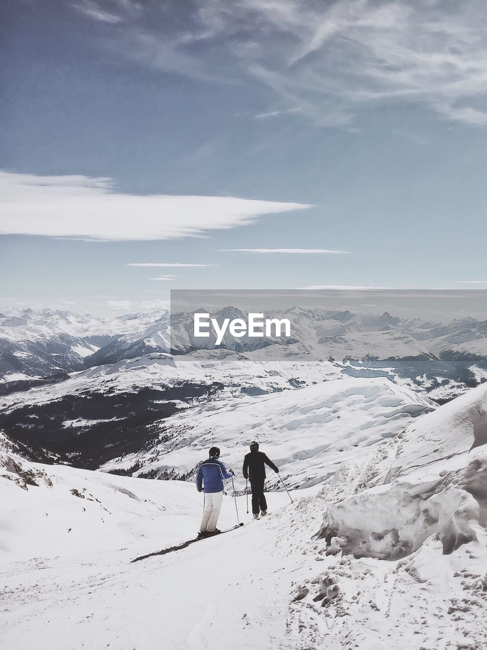 REAR VIEW OF PEOPLE WALKING ON SNOWCAPPED MOUNTAIN AGAINST SKY