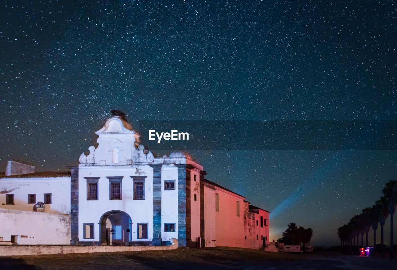 HOUSE AGAINST SKY AT NIGHT