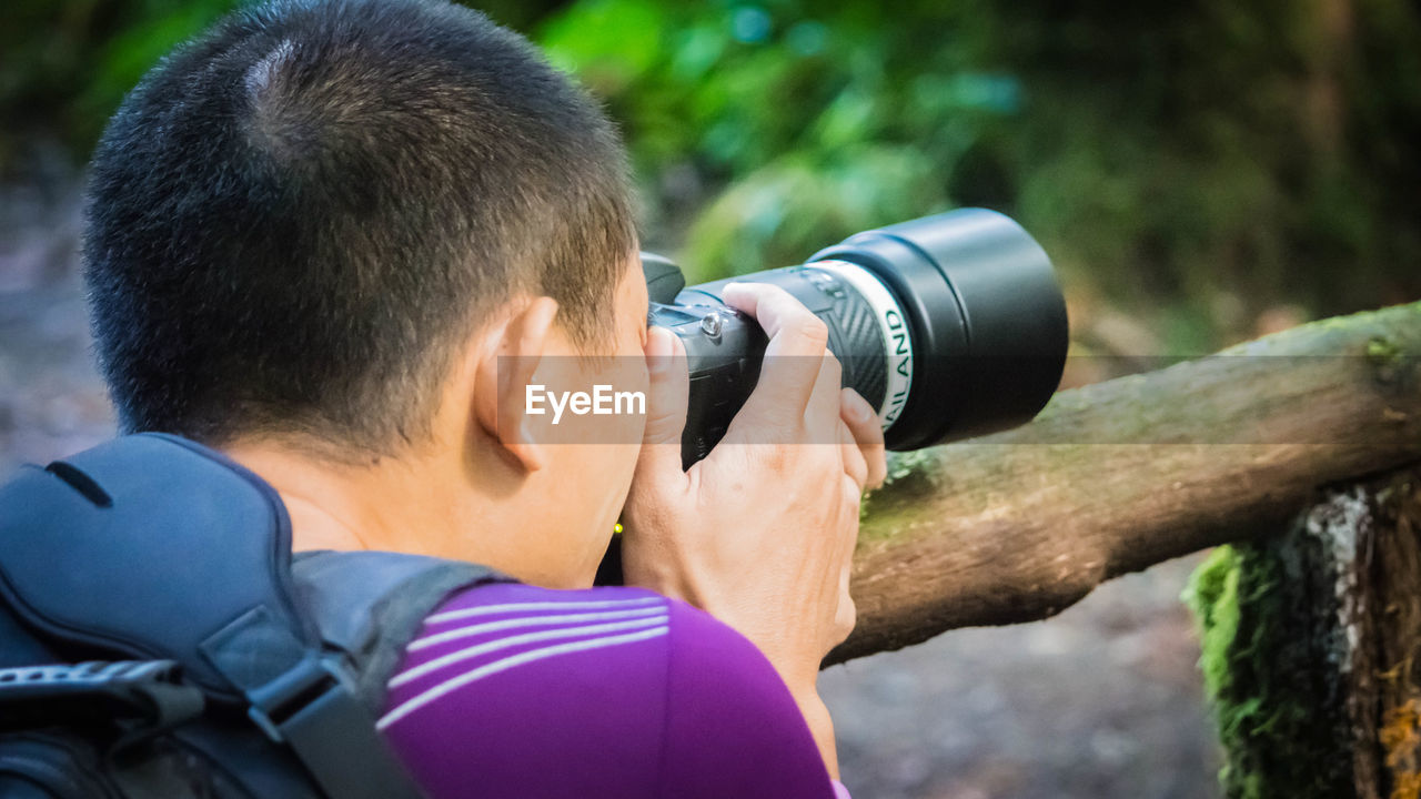 CLOSE-UP OF MAN PHOTOGRAPHING WITH CAMERA