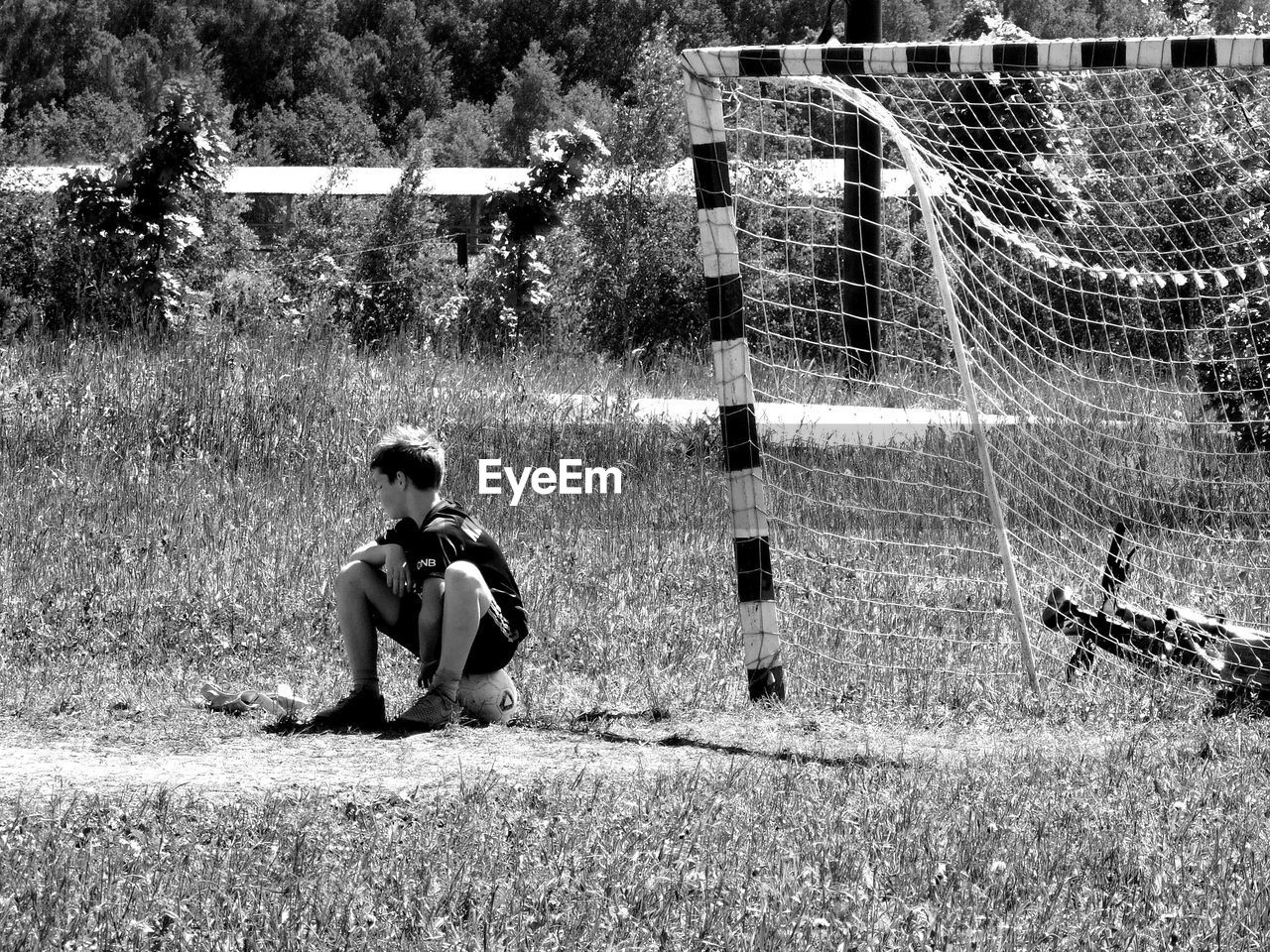 FULL LENGTH OF BOY SITTING ON GRASS