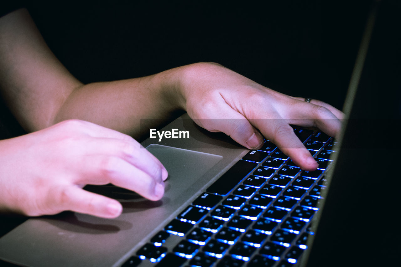 Midsection of person using laptop typing keyboard