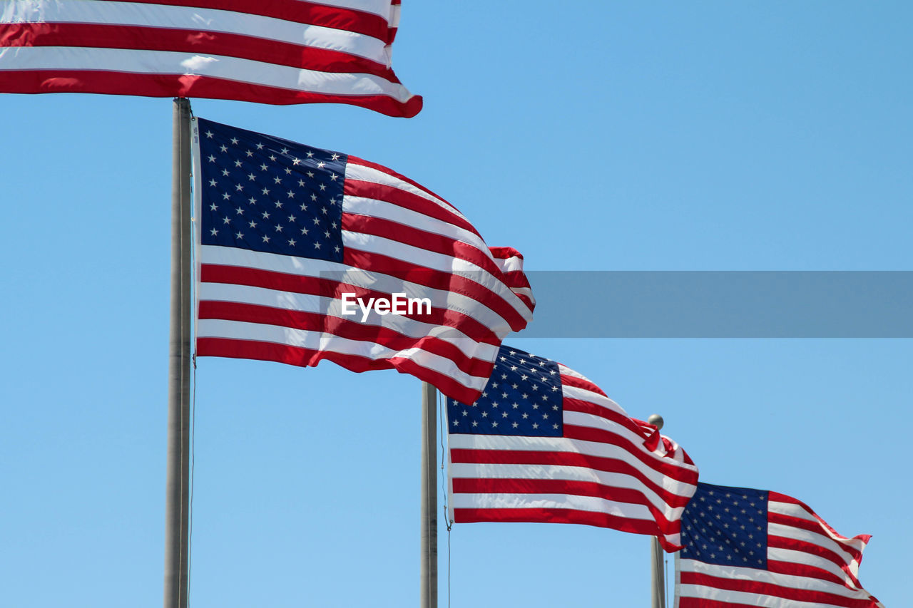 United states flag waving in blue sky without clouds